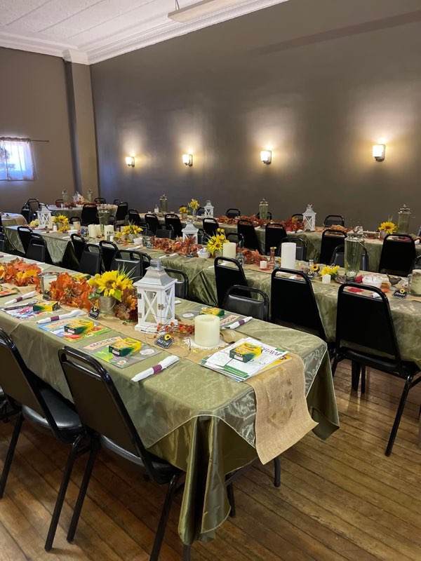 A room at Sally's set with long tables, linens and flowers for an event
