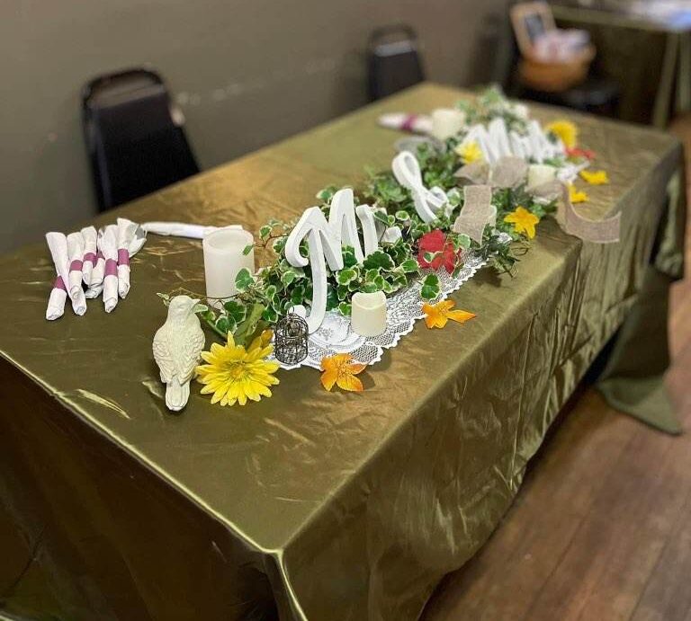 A head table at Sally's decorated with a Mr and Mrs sign and flowers