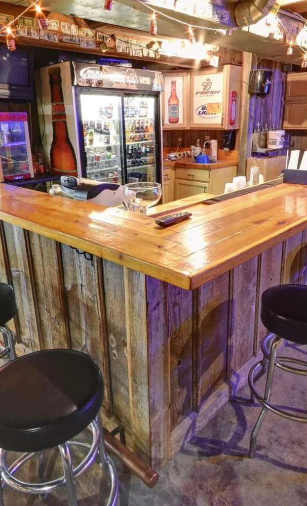 The corner of the reclaimed-wood bar in the Down Under Lounge, coolers stocked behind it