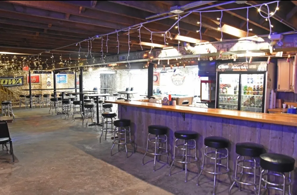 The long bar in the Down Under Lounge with stools along it and string lights overhead