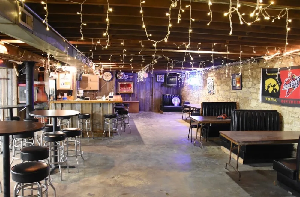 Booth seating and high-top tables in the Down Under Lounge under warm string lights
