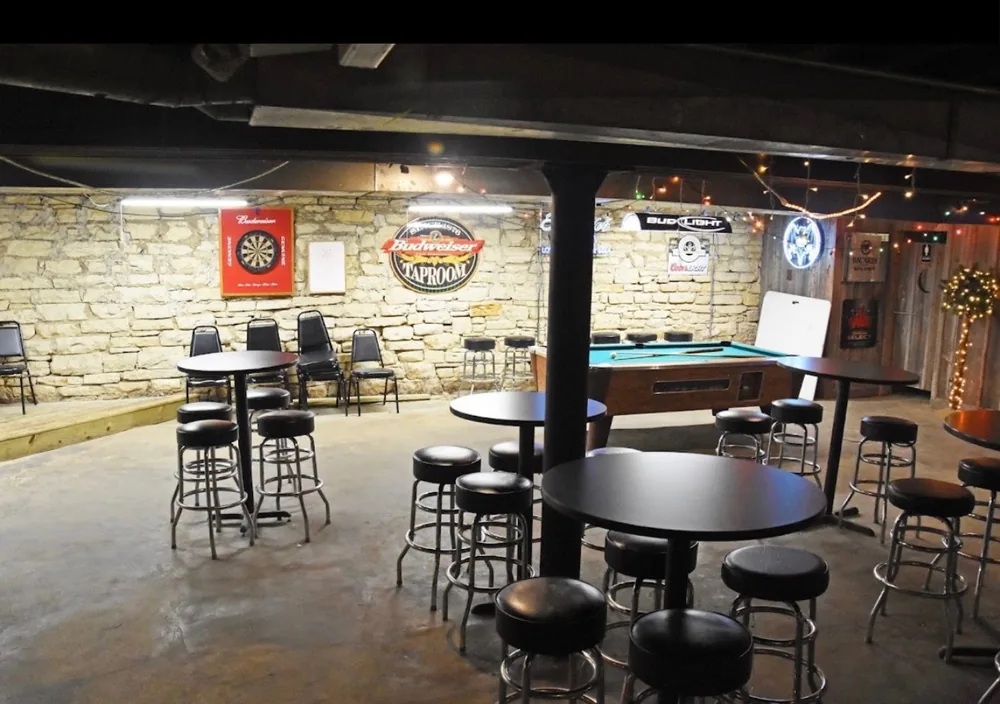 High-top tables and the pool table in the Down Under Lounge, dartboard on the limestone wall