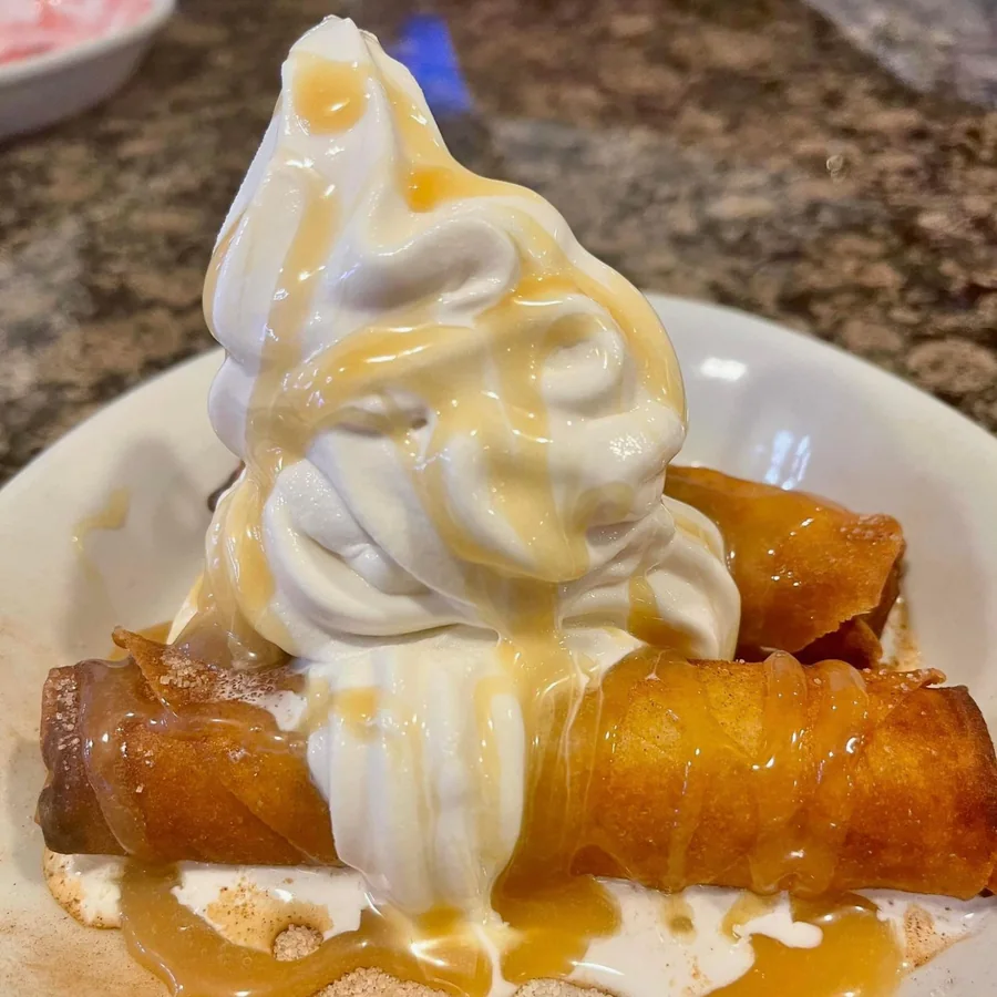Caramel apple dessert egg rolls at Sally's, dusted with cinnamon sugar and topped with soft serve and caramel sauce