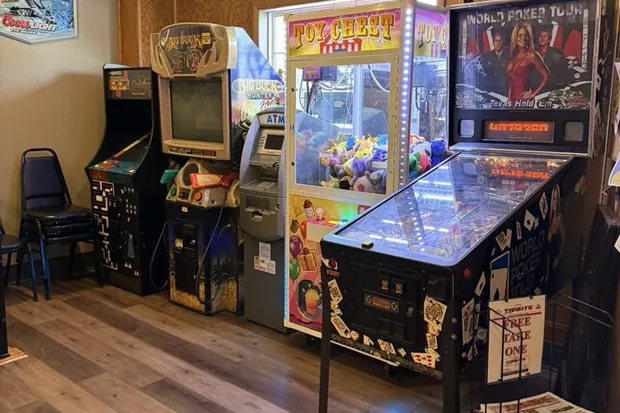 The game room at Sally's, lined with arcade cabinets and a pinball machine