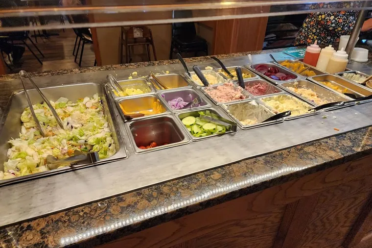 The salad bar at Sally's with toppings laid out in chilled pans