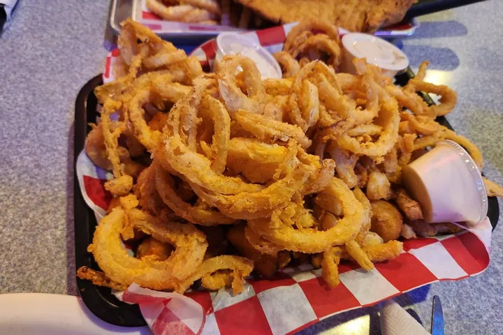 A basket piled high with golden onion rings